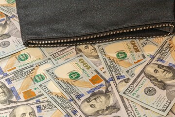 US Dollar Bills and a Black Pouch on a Table, Symbolizing Wealth and Security