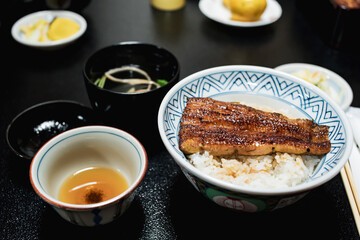 Close up of traditional or local Japanese food - grilled Unagi over rice serve with miso soup, fruit and vegetable. roasted eel cookery. freshness and delicious Japan meals. Juicy food.