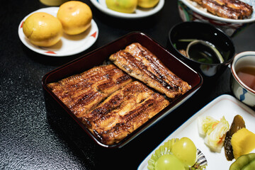 Close up of traditional or local Japanese food - grilled Unagi over rice serve with miso soup, fruit and vegetable. roasted eel cookery. freshness and delicious Japan meals. Juicy food.
