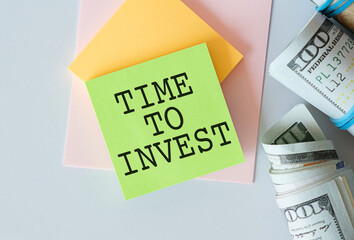 TIME TO INVEST text on a notebook with calculator on diagram background