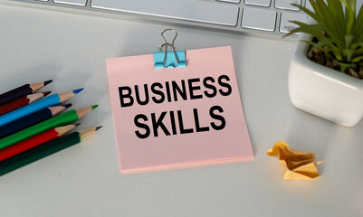 BUSINESS SKILLS text on a notebook with chart on wooden background.