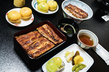 Close up of traditional or local Japanese food - grilled Unagi over rice serve with miso soup, fruit and vegetable. roasted eel cookery. freshness and delicious Japan meals. Juicy food.