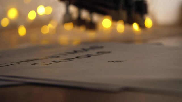 Christmas carol music sheets in front of Christmas lights 