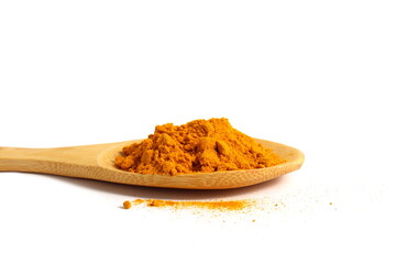 On a white background there is a wooden spoon with turmeric spice.