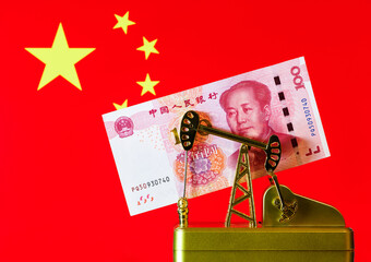 Oil pump and 100 Chinese yuan bill against the background of the Chinese flag