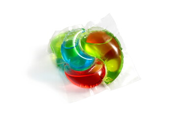 On a white background lies one multi-colored capsule for washing	