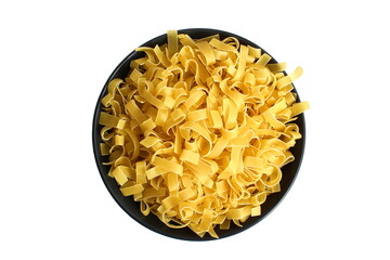 There is a black plate with dry pasta on a white background.