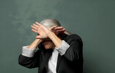  covering face with hand and putting other hand up front to stop camera, refusing photos or pictures