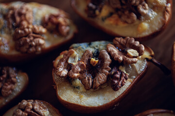 Baked pears topped with walnuts and blue cheese, capturing a rustic and comforting feel