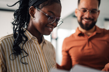 Smiling businesswoman reading documents with male colleague