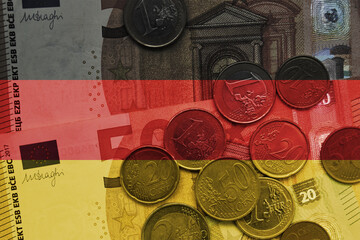colourful national flag of germany on a euro money banknotes and coins background. finance concept.