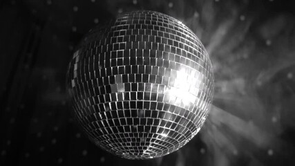 Sparkling silver disco ball spinning in a vibrant atmosphere with dazzling lights during an evening celebration