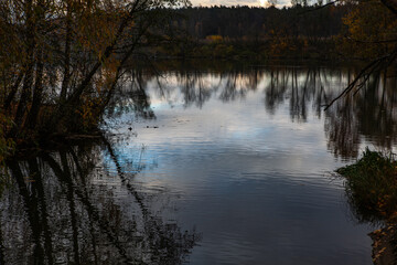 A tranquil scene of the river at Arkhangelskoe Estate in Russia. The water reflects the sky and surrounding trees, creating a peaceful and serene atmosphere.