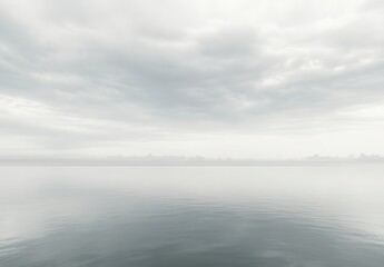 Fototapeta premium Serene Misty Lake Scene with Calm Water Reflection under Overcast Sky, Capturing the Tranquility of Nature and Evoking a Sense of Peace