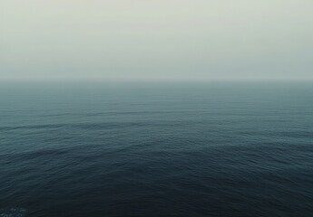 Obraz premium Tranquil Ocean Surface Under Soft Misty Sky at Dusk, Evoking Serenity and Calmness with Gentle Waves Reflecting Natural Beauty and Peaceful Atmosphere