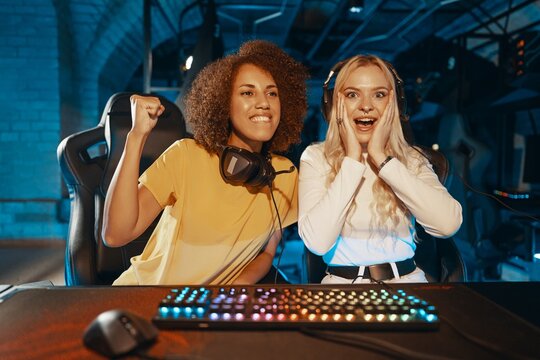 Two friends celebrate victory in an esports competition at a gaming lounge