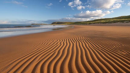 Fototapeta premium beach waves and ocean concept. Serene beach with rippled sand and gentle waves under a blue sky.