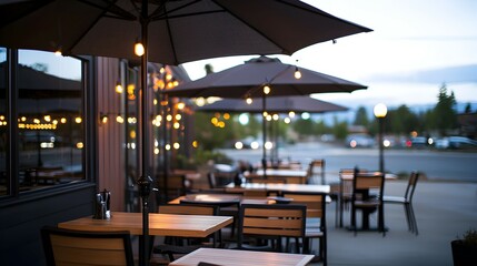 Fototapeta premium Cozy Restaurant Patio at Dusk with Large Umbrellas and Soft Lighting - Inviting Outdoor Dining Space Surrounded by Greenery and a Gentle Glow