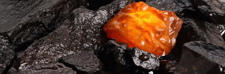Beautiful natural amber piece on wood, showing yellow and red hues