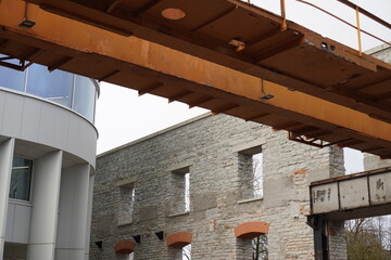 Renovation project showcasing industrial architecture with an orange crane and stone walls in a modern urban setting