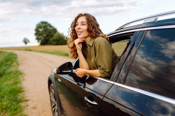 Happy woman on road, enjoying window view and traveling on holiday road trip. Travel, adventure drive.