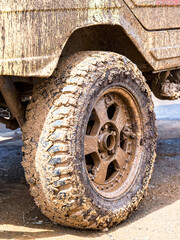 Extremely dirty off-road car wheel after driving heavy off-road