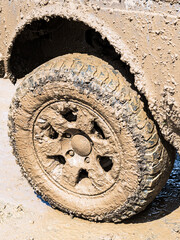 Extremely dirty off-road car wheel after driving heavy off-road