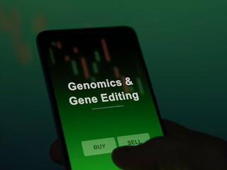 An investor analyzing the genomics & gene editing etf fund on a screen. A phone shows the prices of Genomics & Gene Editing