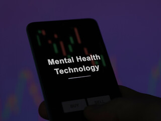 An investor analyzing the mental health technology etf fund on a screen. A phone shows the prices of Mental Health Technology