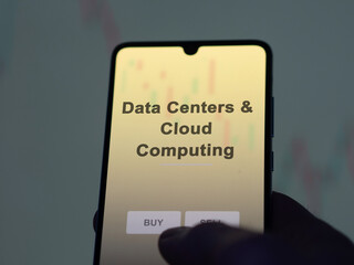 An investor analyzing the data centers & cloud computing etf fund on a screen. A phone shows the prices of Data Centers & Cloud Computing