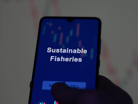 Sustainable fisheries etf fund on a screen. A phone shows the prices of Sustainable Fisheries, An investor analyzing fishery fund.