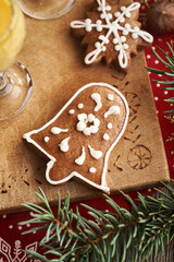 Bell shaped gingerbread Christmas cookie with a glass of Eiecognac on a wooden table with spruce tree branches