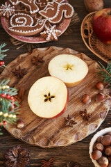 Two halves of a red apple with star shape in the middle with gingerbread Christmas cookies