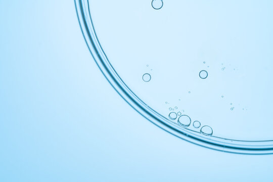 Close-up of bubbles in light blue transparent liquid surface