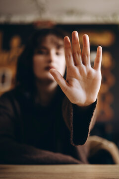 Blurred background emphasizes raised hand in focus