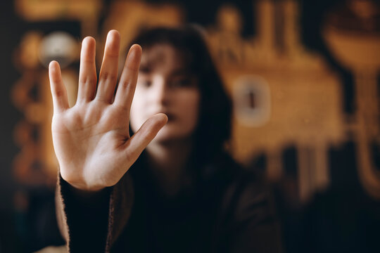 Woman Expressing Stop Gesture with Open Hand Focused in Foreground