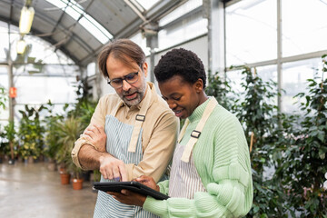 Garden store staff discussing work with digital tablet