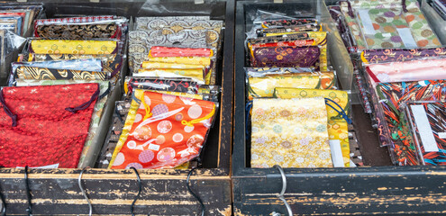 Japanese textiles collection at a shop display, Variety of fabrics with vibrant colors folded on wooden cases