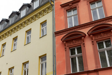 Obraz premium A bright yellow building and a vivid red building are situated right next to each other, creating an interesting visual contrast