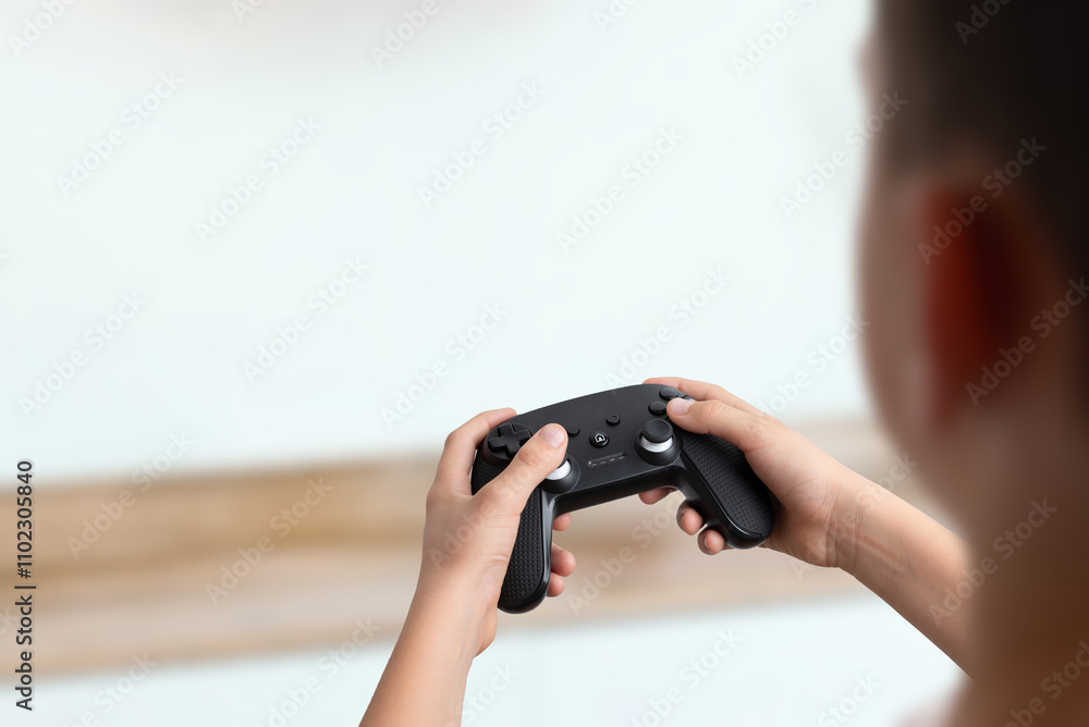 Aufkleber Over the shoulder view of a boy holding a gamepad, clean background with empty space for text, perfect for gaming promotions and creative advertising