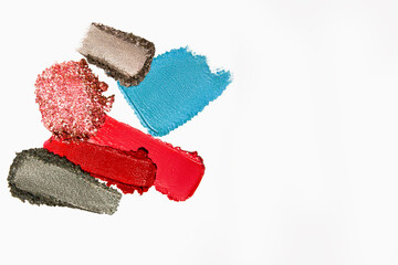 Colorful and vibrant texture composition of lipstick, eyeshadow, bronzer, glitter, and powder with...
