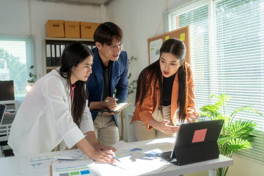 Asian business people having meeting using laptop discussing together in office