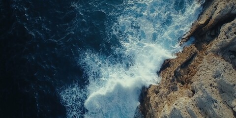 Ocean waves softly hitting the rocky shore under daylight