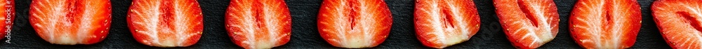 Poster several strawberry slices are meticulously arranged on a dark surface, showcasing their juicy textur