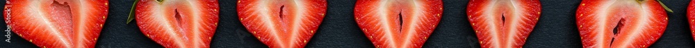 Aufkleber several strawberry halves are neatly arranged on a dark surface, showcasing their juicy red interior