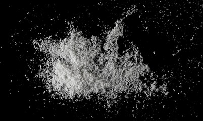 Pile grated coconut isolated on black, top view	