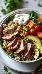 Healthy chicken bowl with quinoa, cherry tomatoes, avocado, and herbs in a rustic dish, food concept