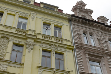 Obraz premium In the urban landscape, a vibrant yellow building stands proudly right next to an earthy brown building, adding charm to the street