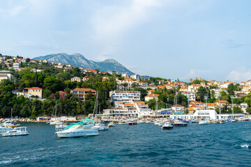 View of Herceg Novi, Montenegro. Yachts and pleasure boats on pier in Balkans, Adriatic Sea. City on side of a mountain