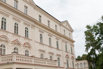 Fototapeta premium A significant and prominent large white building featuring a balcony and several trees located directly in front of it, adding to its charm